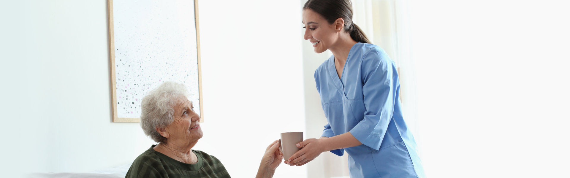 Caregiver giving water to an elderly person